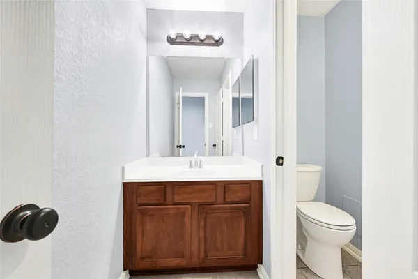 a bathroom with a sink a toilet and mirror