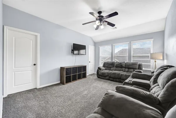 a living room with furniture and a ceiling fan