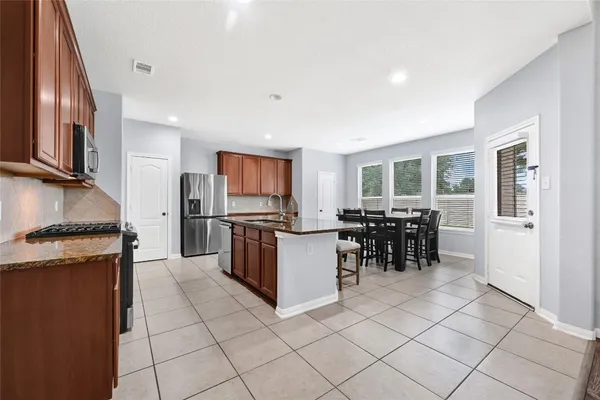 a kitchen with stainless steel appliances granite countertop a refrigerator and a stove top oven