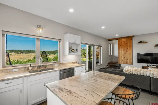 a large kitchen with kitchen island granite countertop lots of counter top space and stainless steel appliances