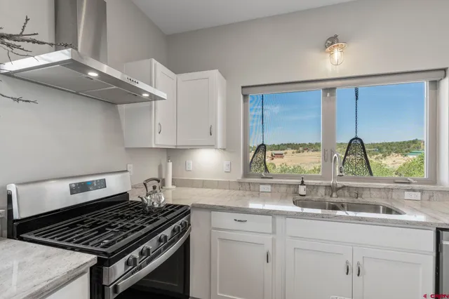 a kitchen with granite countertop a stove and a sink