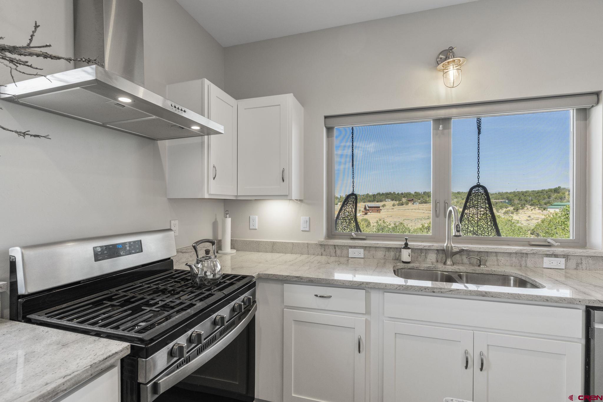68 Cody Road Durango, CO 81303 - Photo 25 of 45 a kitchen with granite countertop a stove and a sink