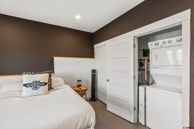 a bedroom with a bed and a refrigerator