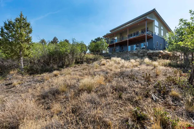 a view of a house with a yard and wooden fence