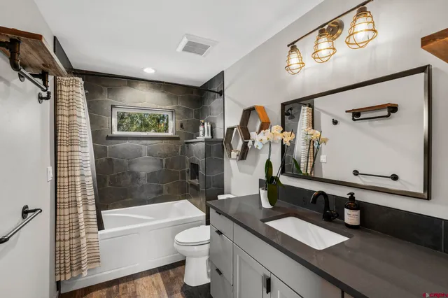 a bathroom with a granite countertop sink toilet and shower
