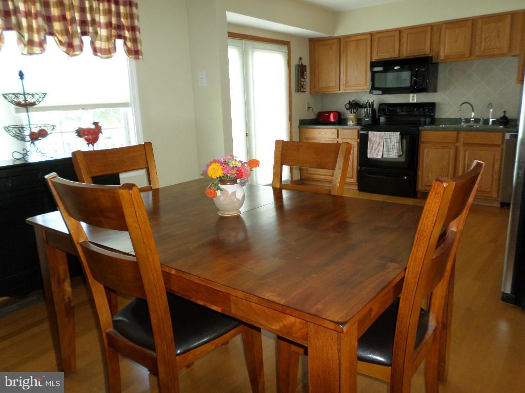 2520 Neudecker Road Westminster, MD 21157 - Photo 5 of 27 a kitchen with a dining table chairs and a refrigerator