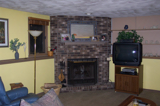 4234 Montclair Road Roscoe, IL 61073 - Photo 5 of 6 a living room with furniture a flat screen tv and a fireplace