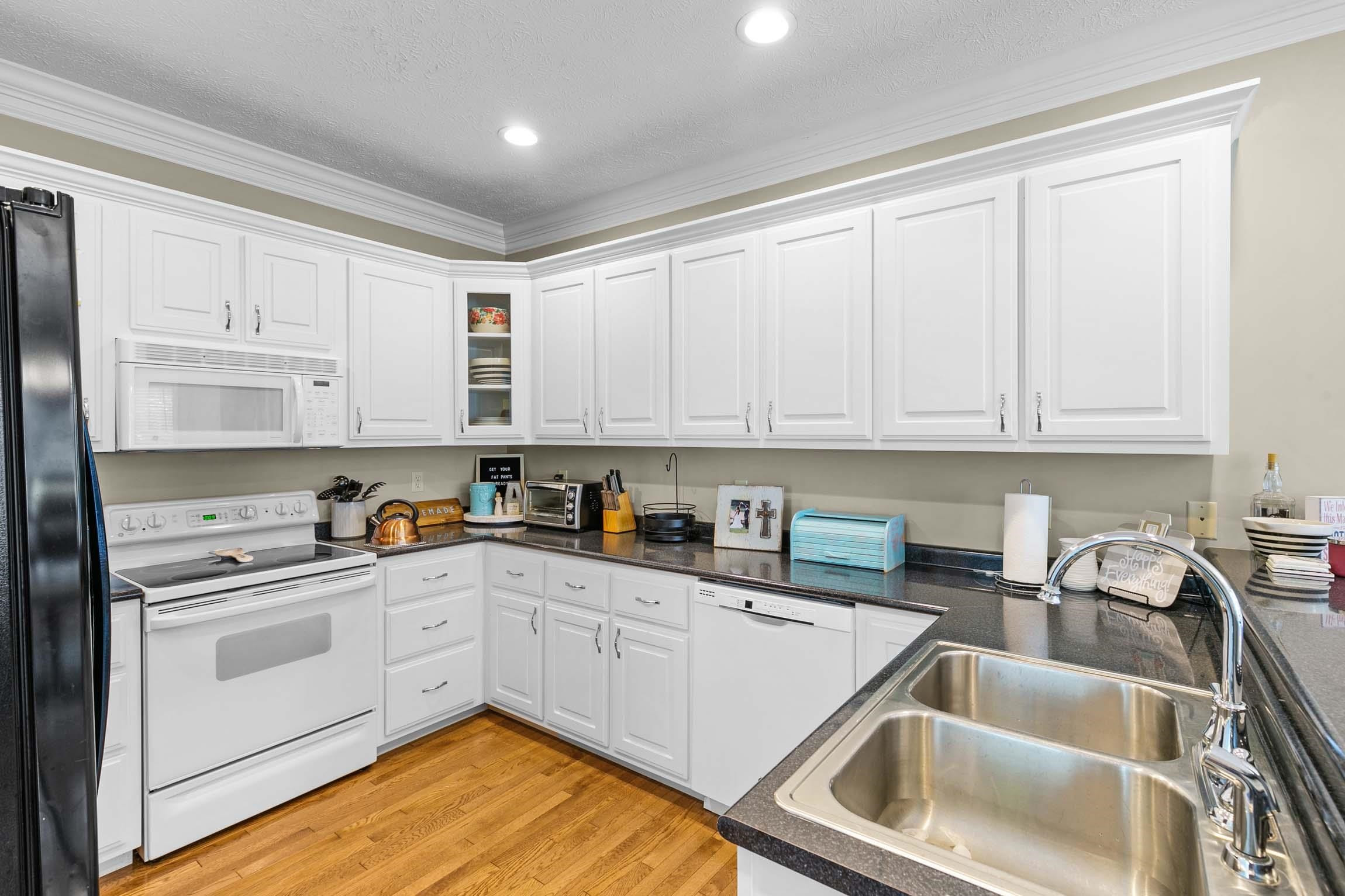 335 Booth Loop Henderson, TN 38340 - Photo 5 of 20 a kitchen with white cabinets sink and white appliances
