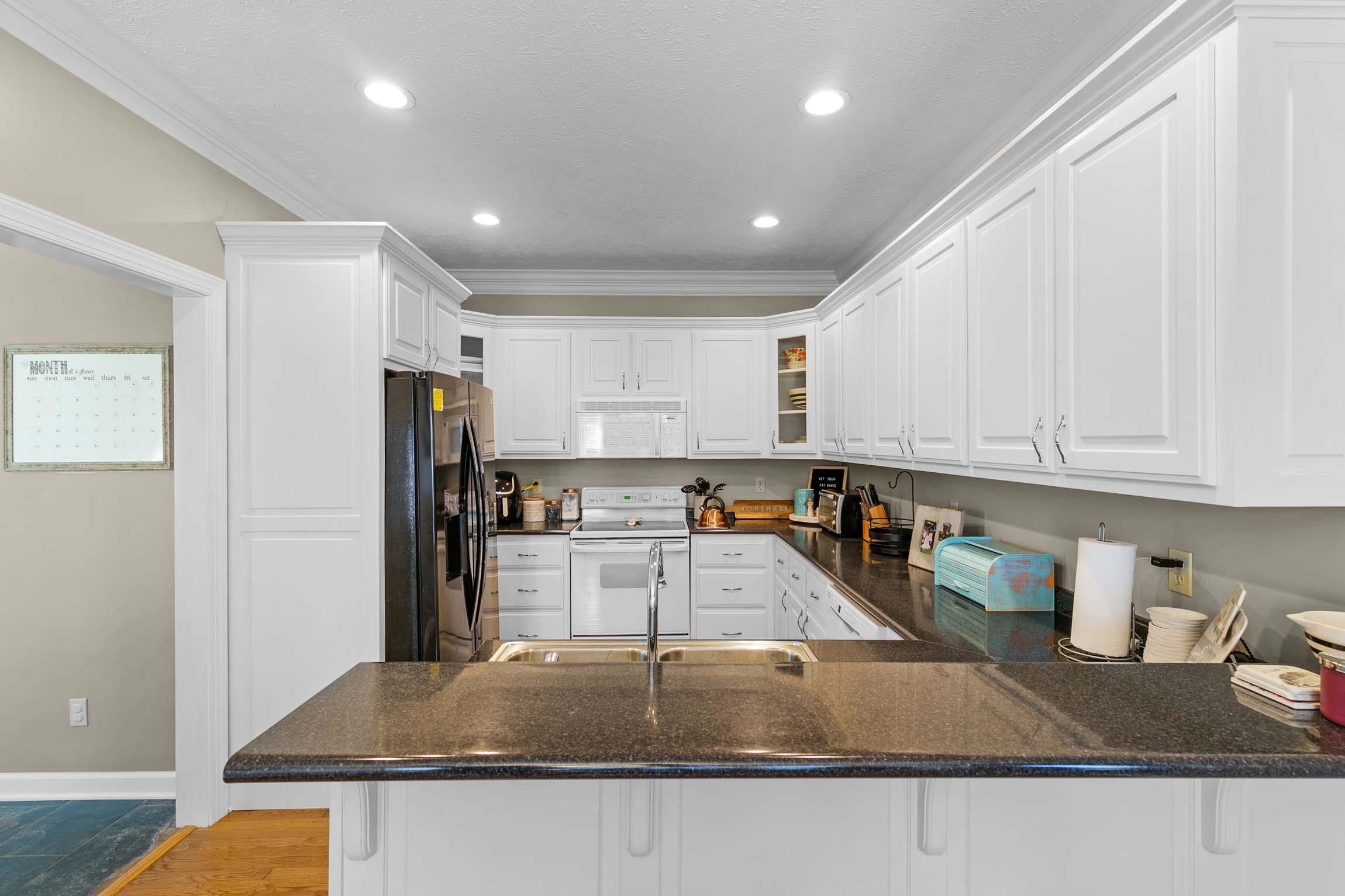 335 Booth Loop Henderson, TN 38340 - Photo 6 of 20 a kitchen with stainless steel appliances granite countertop a sink a stove and a refrigerator