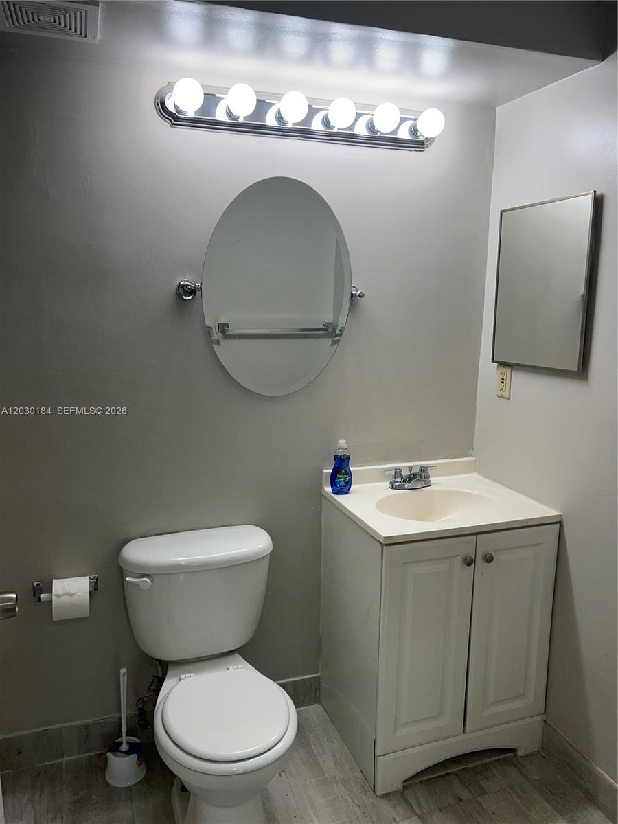 951 Lyons Road, Unit 6104 Coconut Creek, FL 33063 - Photo 4 of 18 a bathroom with a toilet sink and mirror