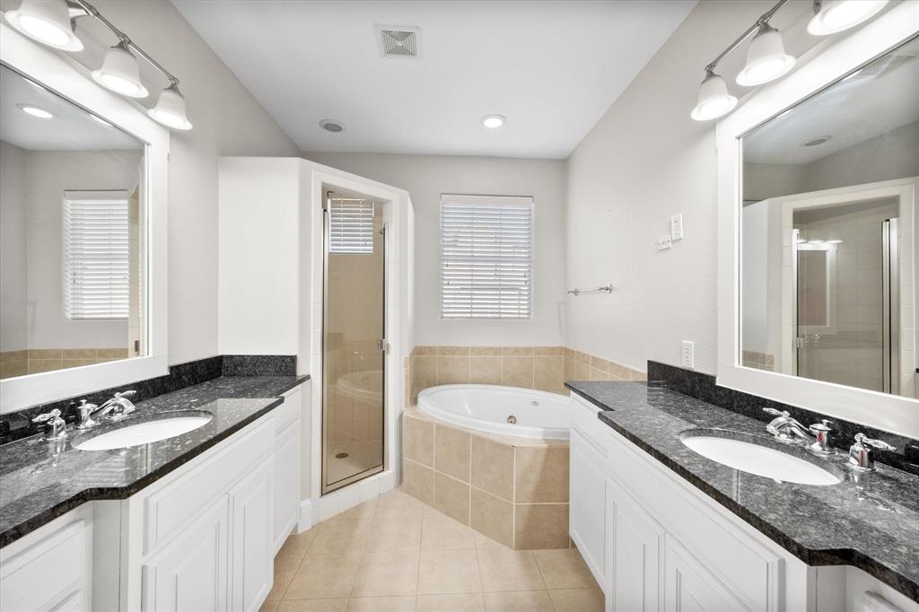 a bathroom with a granite countertop tub sink and mirror