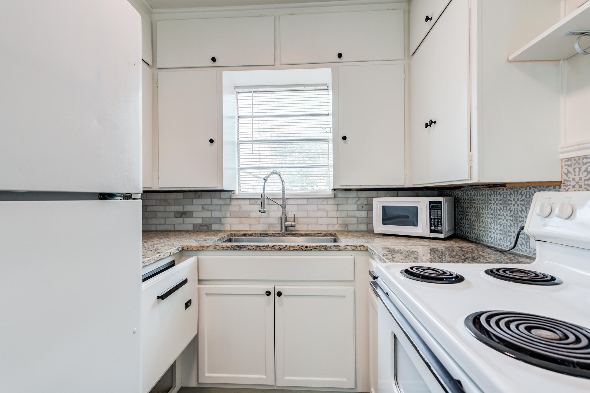 2308 30th Street Lubbock, TX 79411 - Photo 13 of 21 a kitchen with a stove a sink and a refrigerator