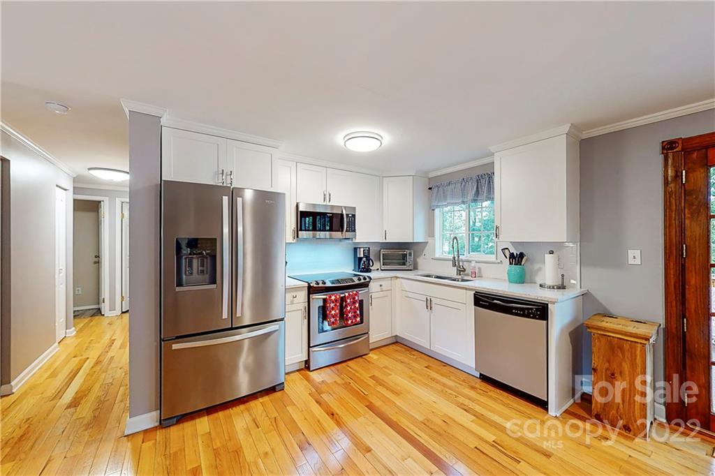 12118 Mapleton Road Charlotte, NC 28273 - Photo 11 of 48 a kitchen with granite countertop a refrigerator and a stove top oven