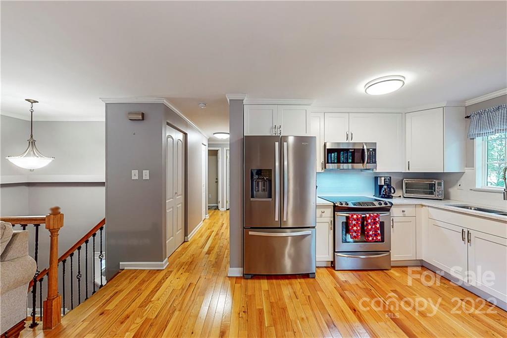 12118 Mapleton Road Charlotte, NC 28273 - Photo 14 of 48 a kitchen with stainless steel appliances a refrigerator a stove and white cabinets