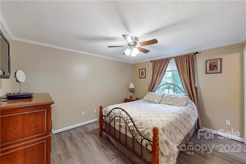 12118 Mapleton Road Charlotte, NC 28273 - Photo 21 of 48 a bedroom with a bed and a chandelier