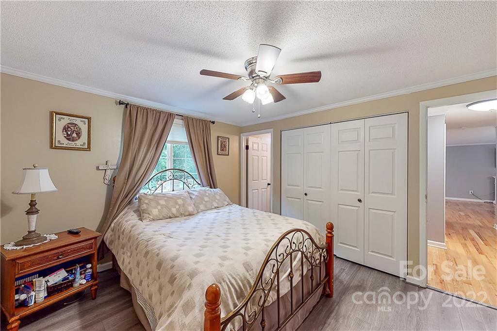 12118 Mapleton Road Charlotte, NC 28273 - Photo 23 of 48 a bedroom with a bed and a chandelier