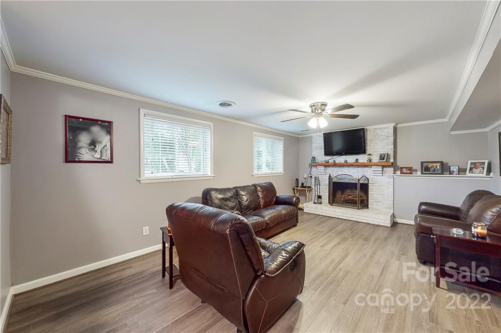 12118 Mapleton Road Charlotte, NC 28273 - Photo 30 of 48 a living room with furniture a fireplace and a flat screen tv