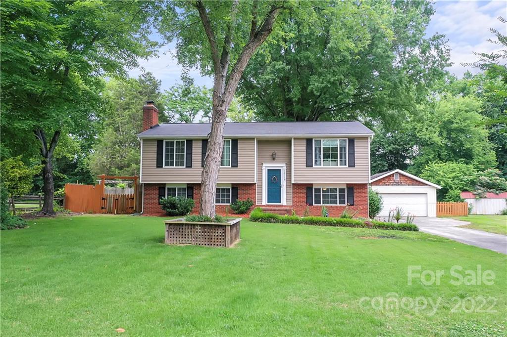 12118 Mapleton Road Charlotte, NC 28273 - Photo 44 of 48 a front view of a house with a garden and trees