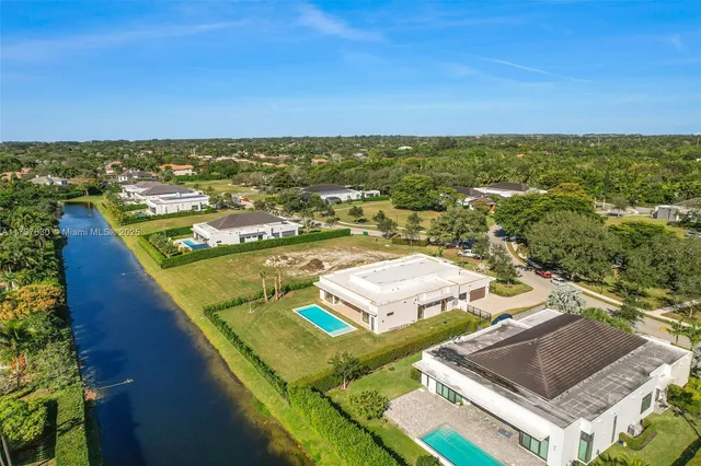 an aerial view of residential houses with outdoor space and swimming pool