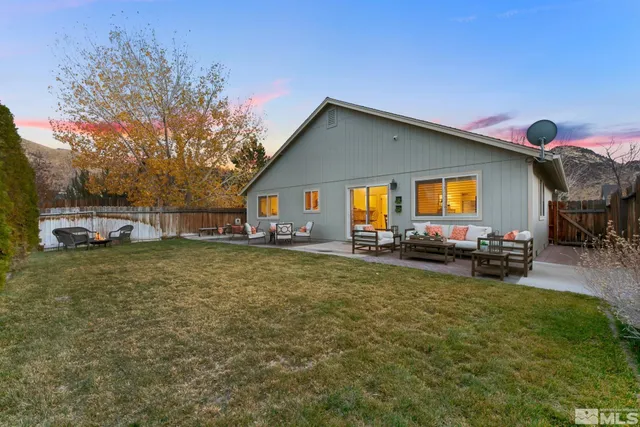 a view of a house with backyard and sitting area