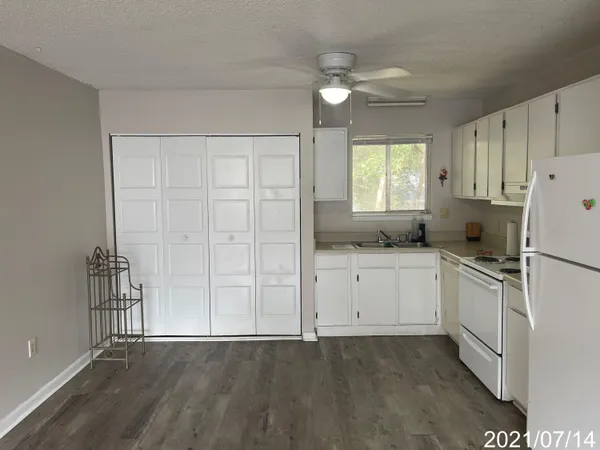 a kitchen with granite countertop white cabinets and white appliances