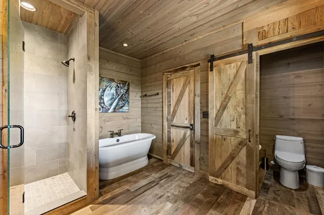 an aerial view of a house with balcony and trees al around