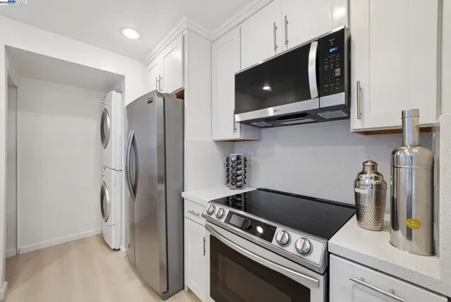 a kitchen with stainless steel appliances granite countertop a refrigerator and a stove top oven
