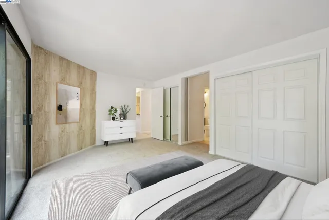 a bedroom with a bed and a large mirror