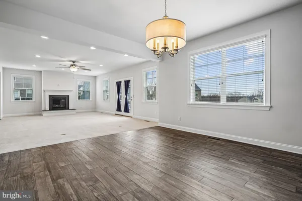 a kitchen with stainless steel appliances granite countertop a refrigerator a sink dishwasher a stove and white cabinets with wooden floor