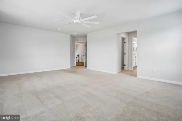 an empty room with a window and a ceiling fan
