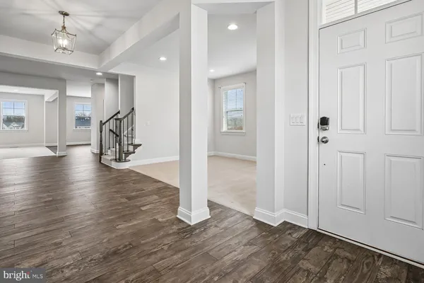 a view of an empty room with chandelier fan and windows