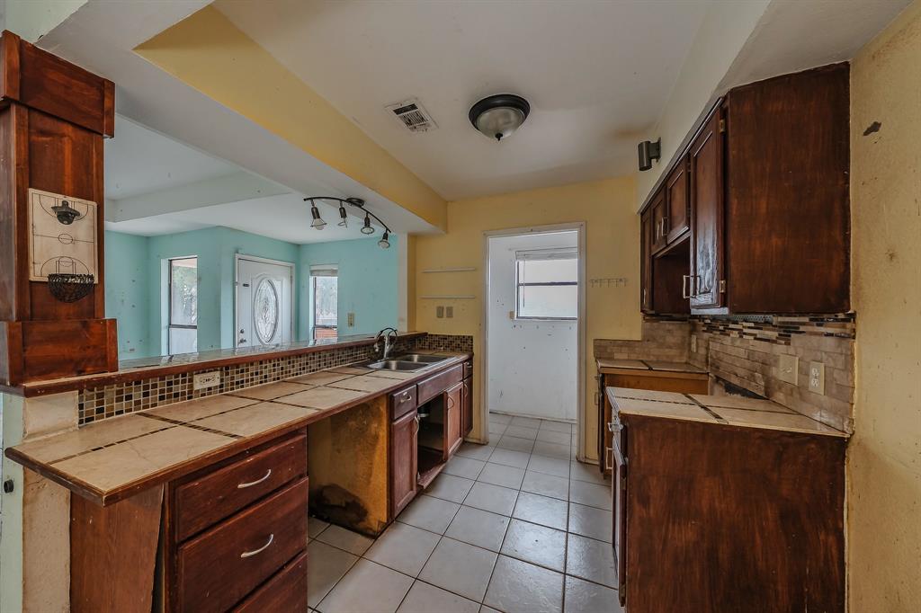 5709 Ranchogrande Drive Arlington, TX 76017 - Photo 11 of 28 a kitchen with a stove and a sink