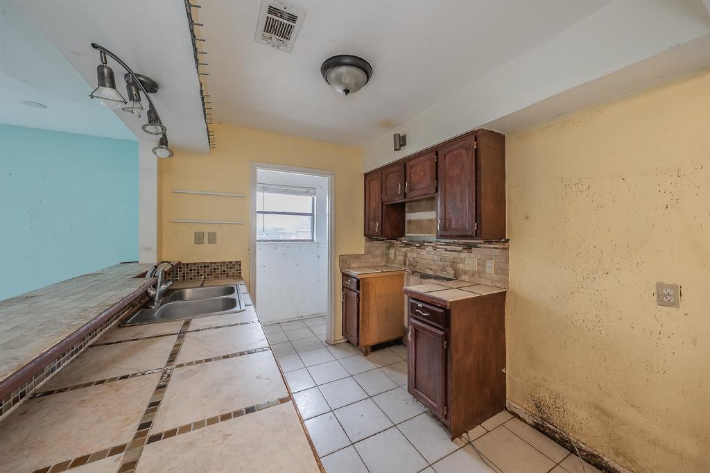 5709 Ranchogrande Drive Arlington, TX 76017 - Photo 12 of 28 a kitchen with a sink a stove top oven and cabinets