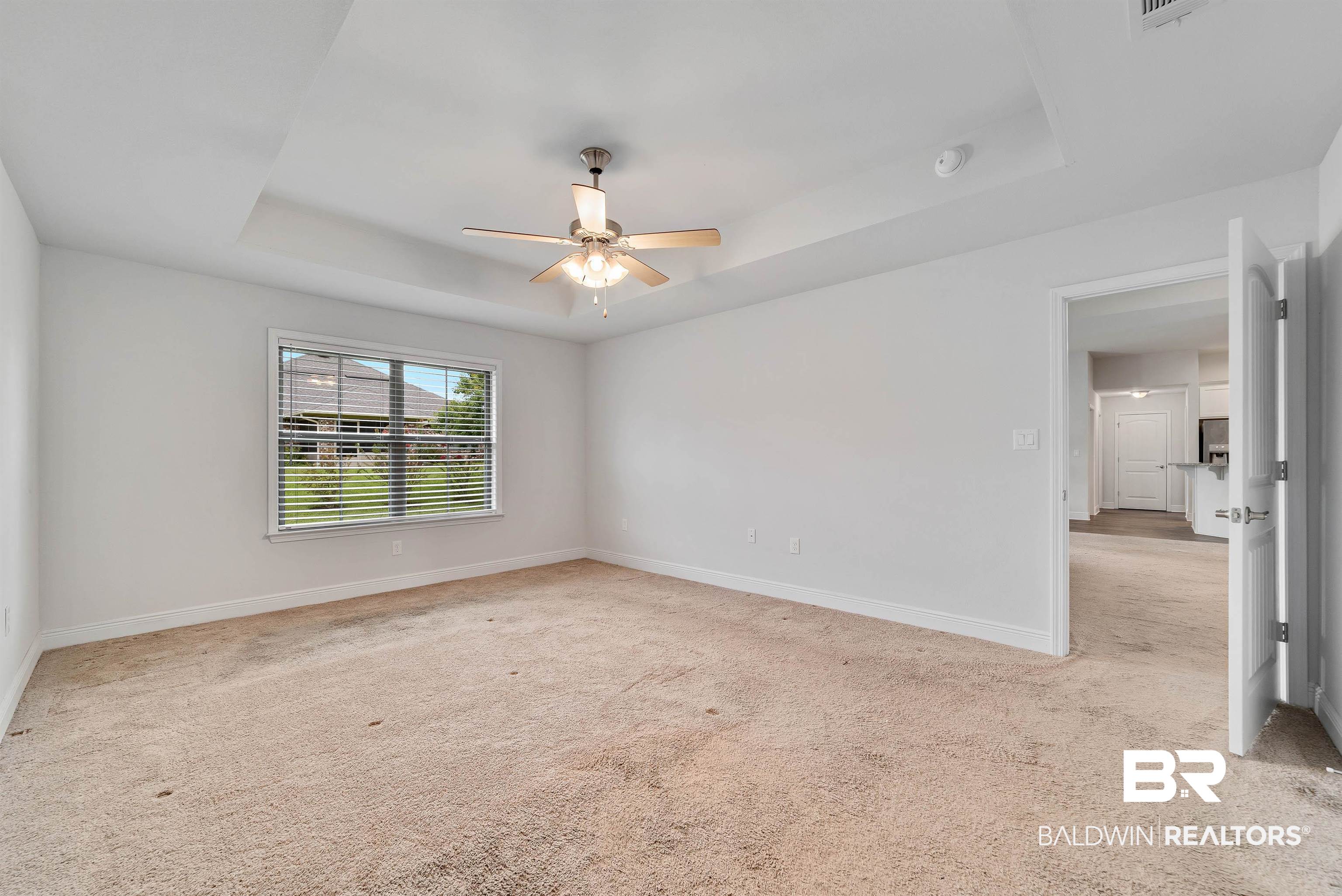 13155 Wishbone Court Foley, AL 36535 - Photo 19 of 39 Carpeted spare room featuring a tray ceiling and ceiling fan