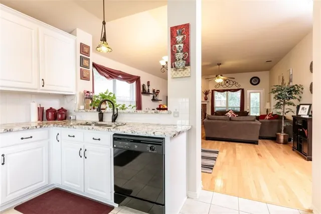 a kitchen with granite countertop a sink cabinets and window