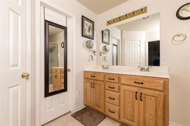 a bathroom with double vanity sink and a mirror