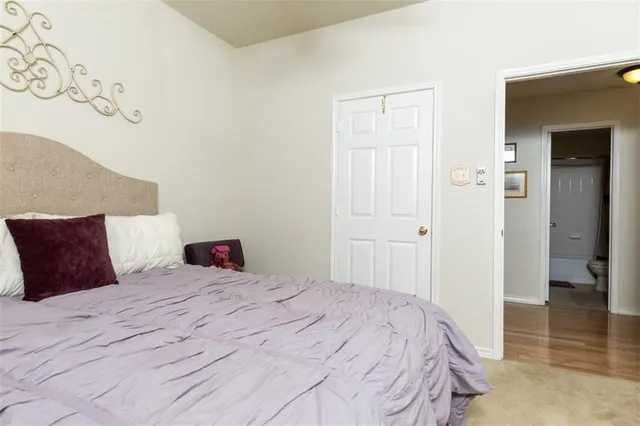 a bedroom with a large bed and wooden floor