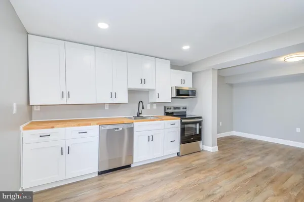 a kitchen with stainless steel appliances a stove a sink and a refrigerator