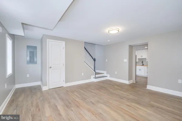 a view of an empty room with wooden floor and closet