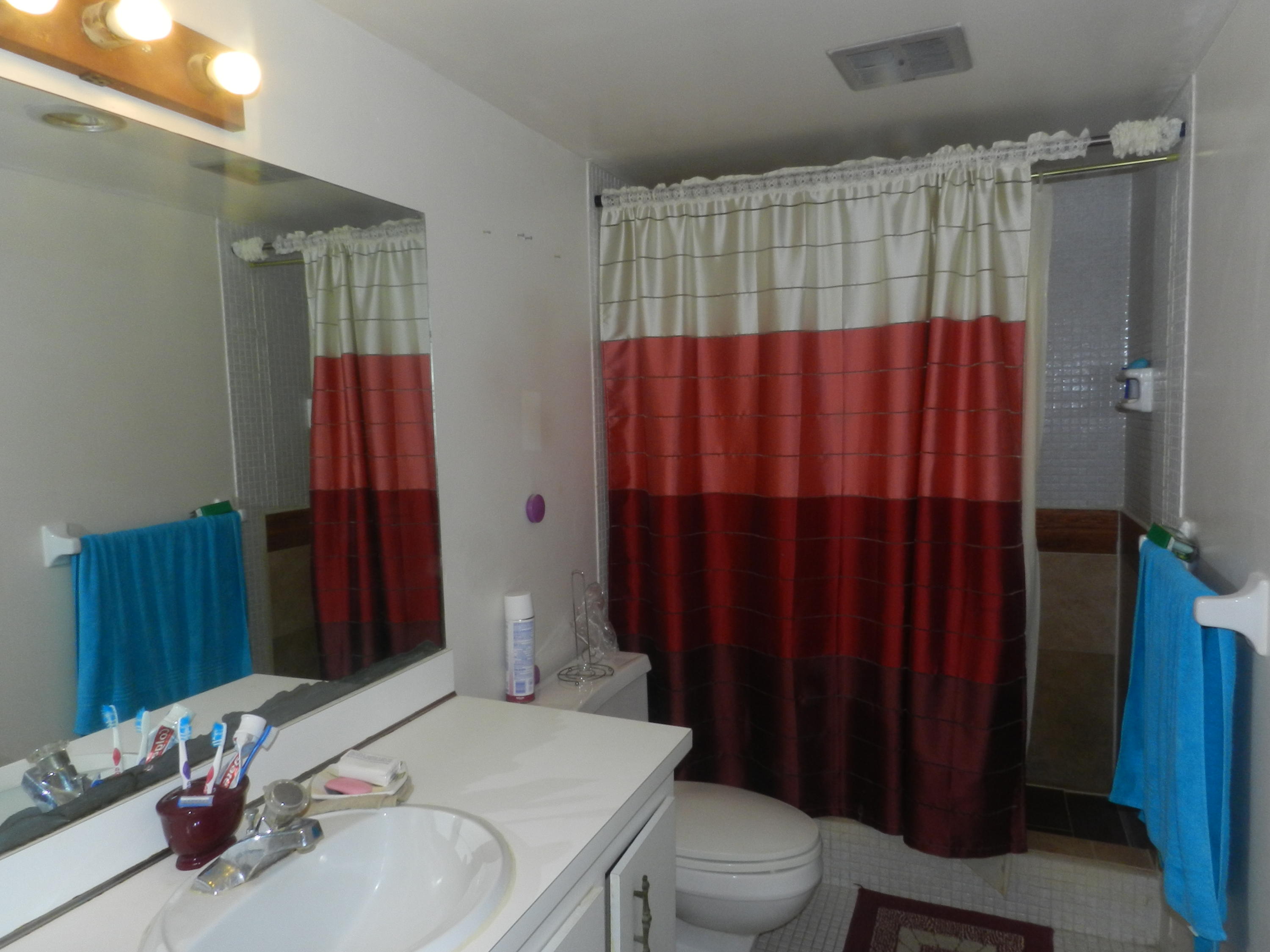 4160 Inverrary Drive, Unit 401 Lauderhill, FL 33319 - Photo 4 of 9 a bathroom with a sink a toilet and shower curtain