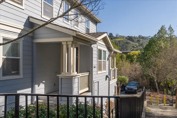 a view of a brick house with iron fence