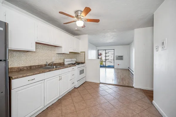 a kitchen with white cabinets and white appliances