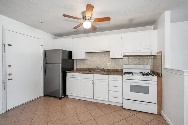 a kitchen with stainless steel appliances granite countertop a stove a refrigerator and a cabinets