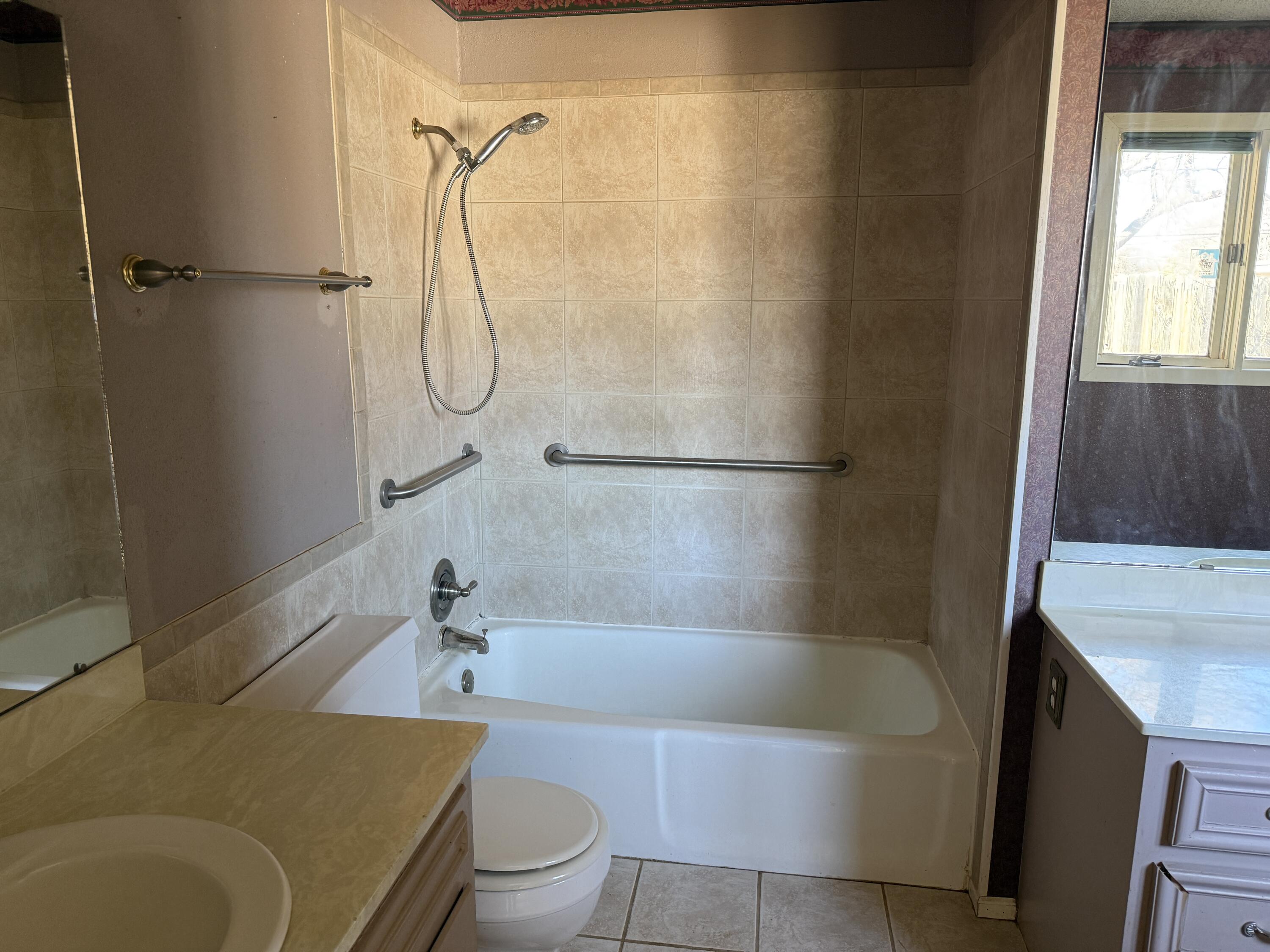 4418 58th Street Lubbock, TX 79414 - Photo 9 of 11 a bathroom with a sink a bath tub and a shower