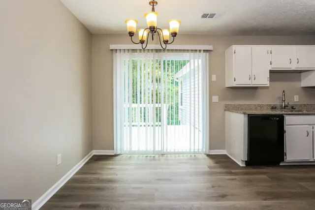 a view of kitchen with granite countertop cabinets and a wooden floor