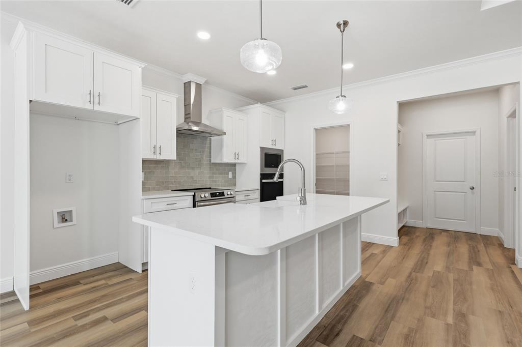 6718 Southwest 10th Lane Gainesville, FL 32607 - Photo 11 of 29 a large kitchen with kitchen island a stove a sink a center island and wooden floor
