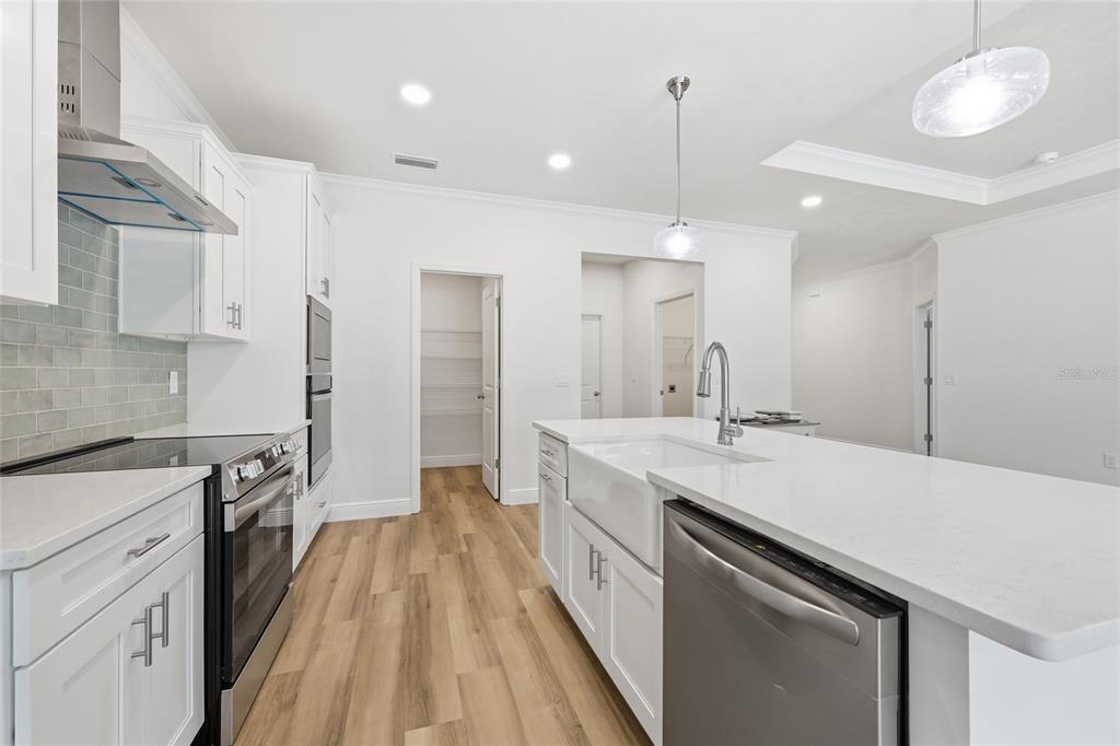 6718 Southwest 10th Lane Gainesville, FL 32607 - Photo 13 of 29 a large kitchen with a sink and dishwasher stove a refrigerator a sink with wooden floors