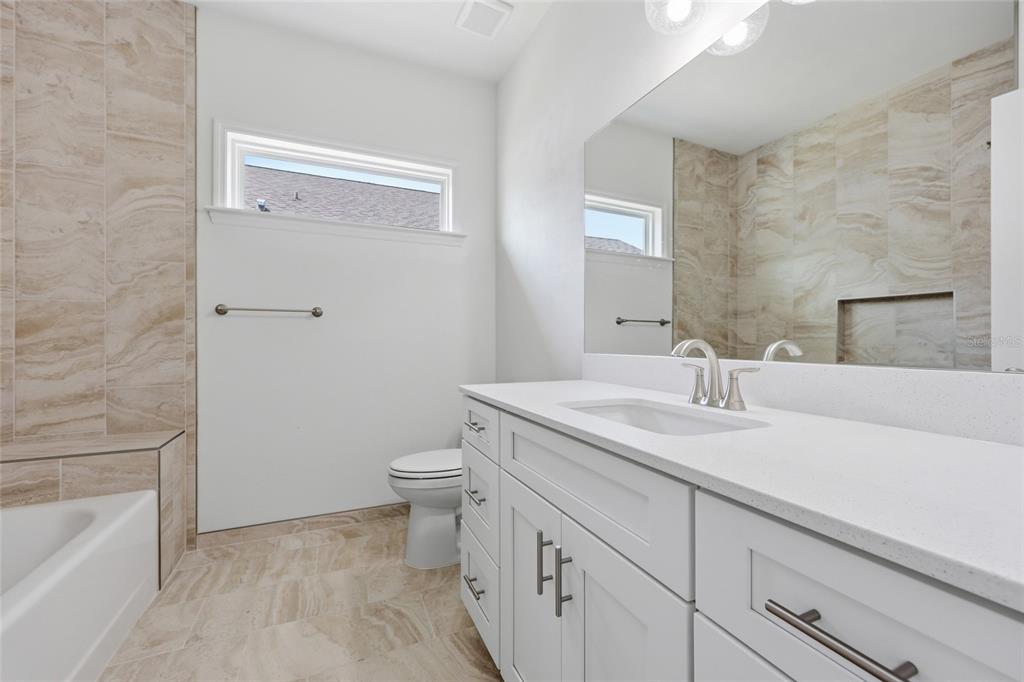 6718 Southwest 10th Lane Gainesville, FL 32607 - Photo 21 of 29 a bathroom with a granite countertop sink a toilet and bathtub
