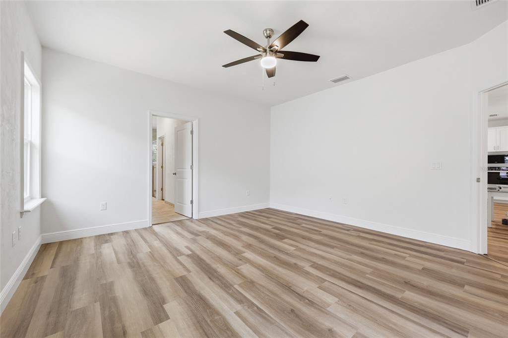 6718 Southwest 10th Lane Gainesville, FL 32607 - Photo 5 of 29 a view of empty room with wooden floor and ceiling fan