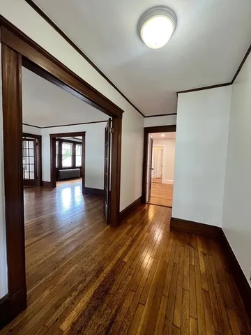 a view of empty room with wooden floor